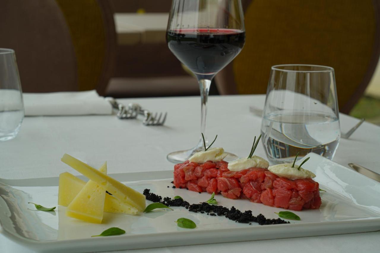 Pisa Tower Plaza Hotel Exterior foto A glass of red wine with a plate of tartar